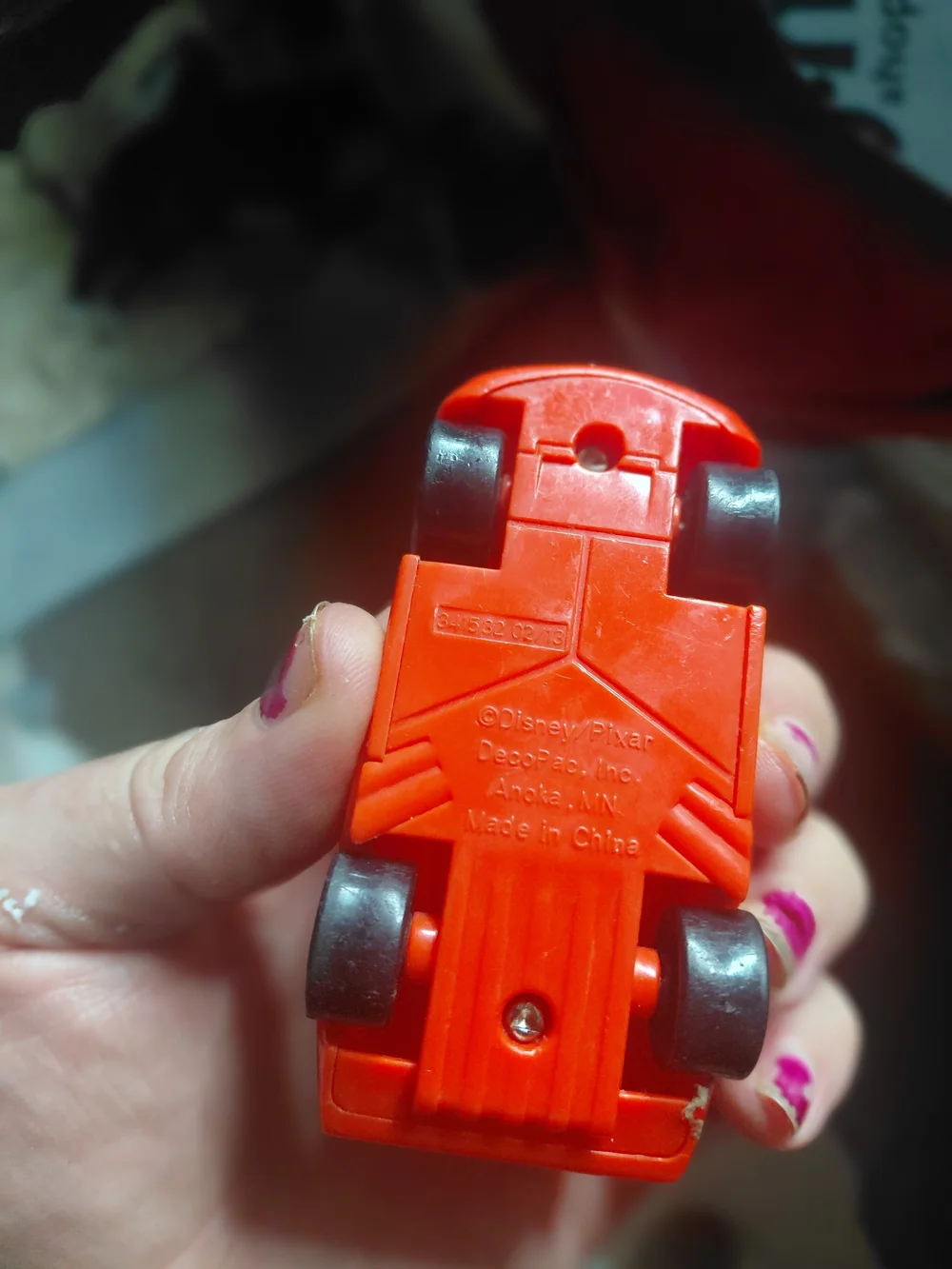 red Disney Pixar Lightning McQueen toy car, appearing to be a plastic model.